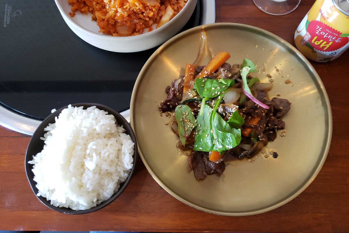 Bulgogi beef with greens beside a bowl of rice