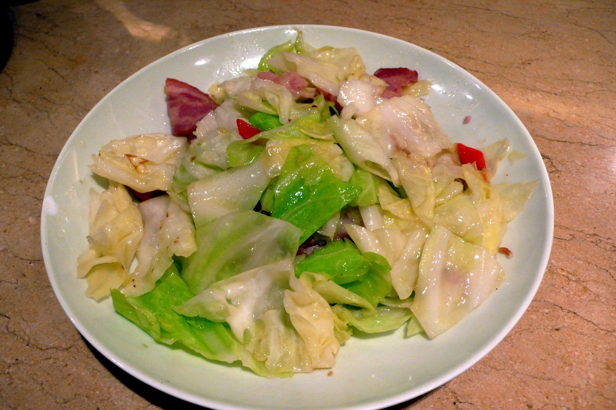 Stir-fried cabbage with pork on a white plate