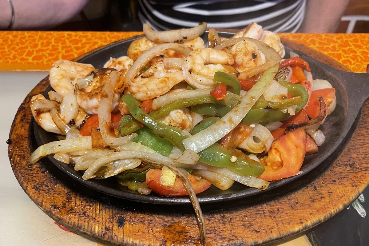 Sizzling pan of shrimp fajitas with peppers and onions